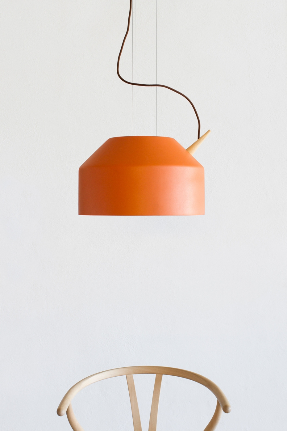 Designerska lampa Reeno w kolorze pomarańczowym.